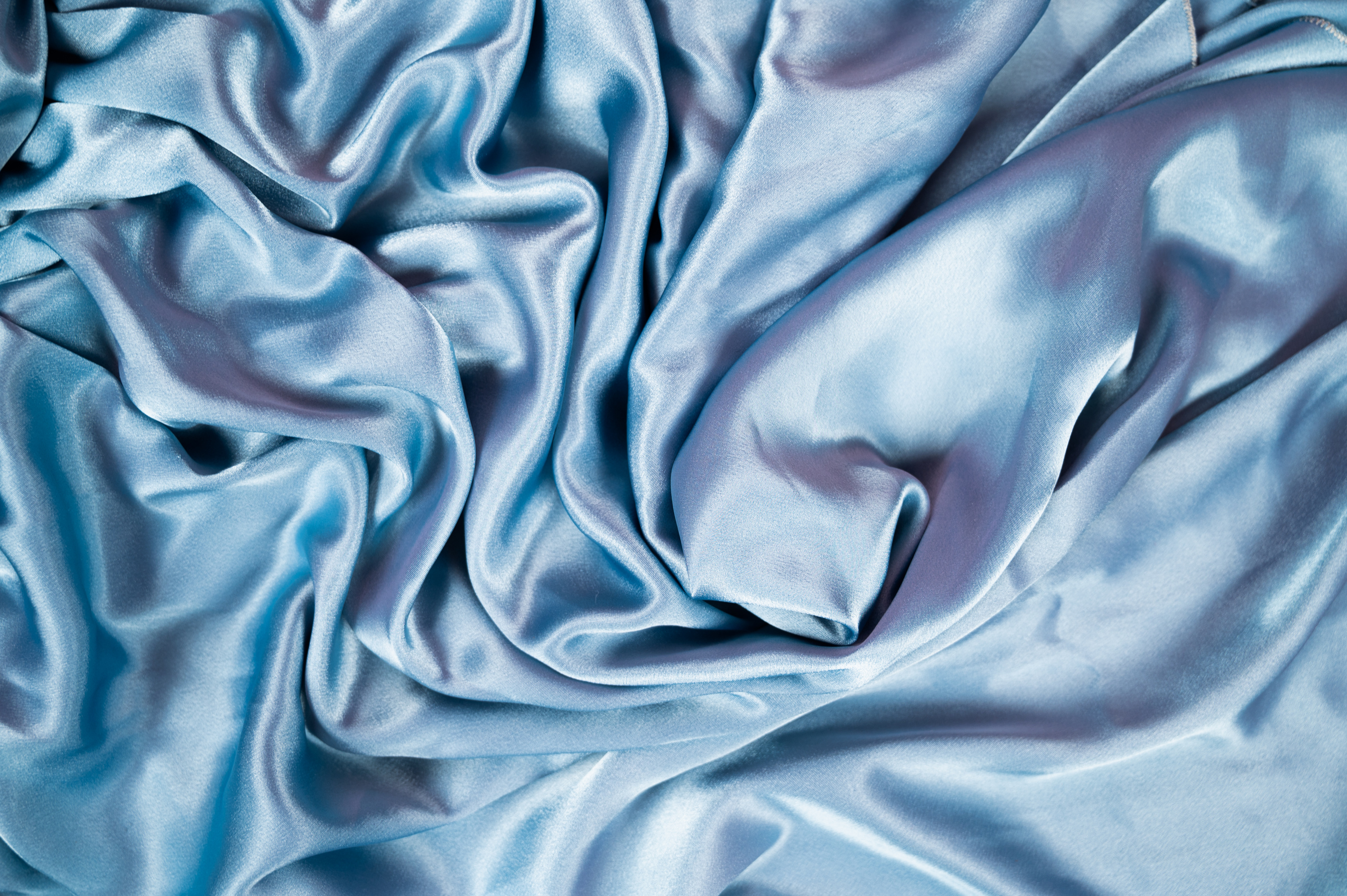 Light blue satin background and texture. Grooved of blue fabric abstract. Top view with empty space.